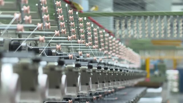 Industrial automation factory production line weaving polypropylene yarn spools bags textile spinning machine. White thread reels with ropes making plastic sacks or fabric process in nylon manufacture