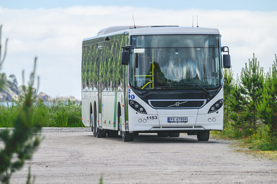 Lindesnes, Norway - June 13 2026: Public transit bus driving along quiet coastal rural road.