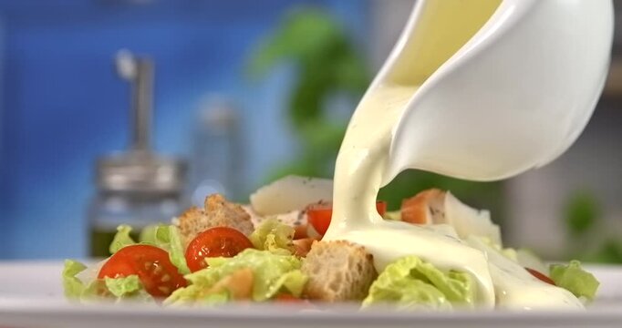 Caesar dressing pouring over fresh caesar salad slow motion 1000 fps