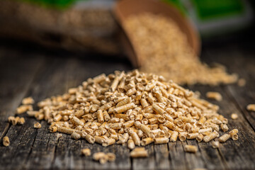 Obraz premium Scoop of Wood Pellets Spilling From Bag for Heating Fuel and Sustainable Biomass Energy