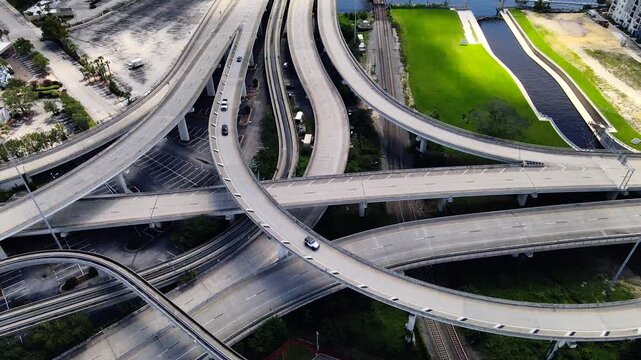 Moving vehicles follow sweeping ramps above layered roads in Jacksonville 4K video.
