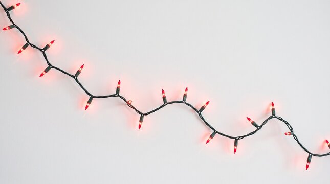 Elegant string of Christmas lights in red and gold against a white background