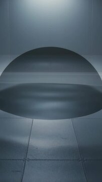 Vertical video: Showing large dark semicircular disc rippling on tile floor while lamp warming