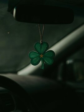 Green shamrock clover sign hanging from car rearview mirror closeup