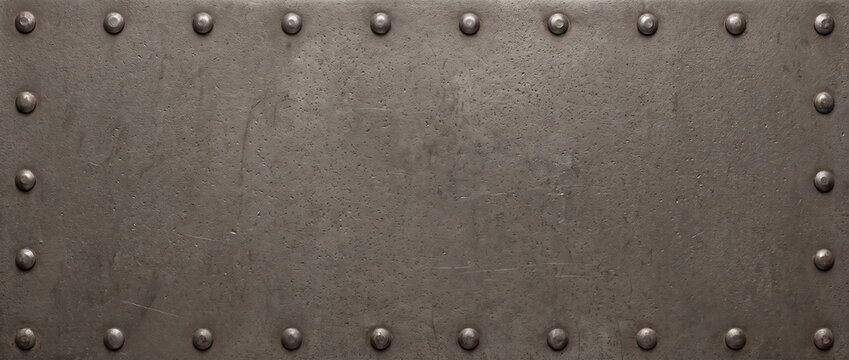 Industrial riveted metal texture with steel bolts around frame. Dark weathered iron plate background. Copy space