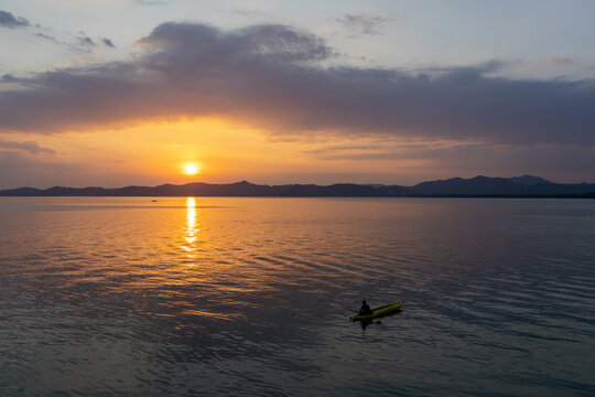 Lone Kayaker Silhouetted on a Golden Bay at Sunset
