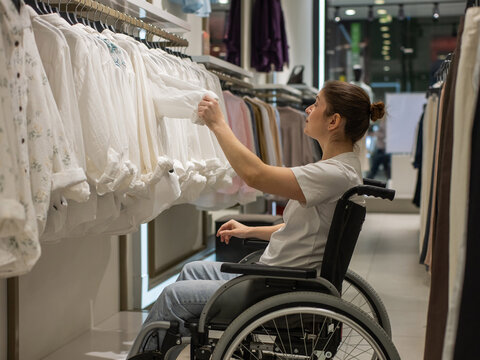 A Caucasian woman in a wheelchair shopping at a mall. 