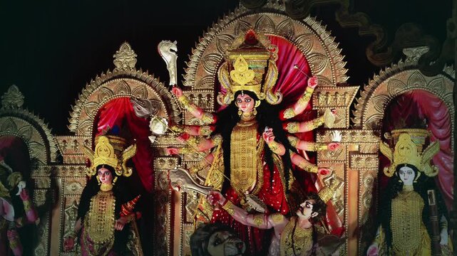 Happy Navratri Illuminated Durga Puja pandal with Maa Durga idol and family Lakshmi, Saraswati, Kartik and Ganesha at night