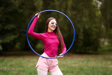 Athletic young woman with hula hoop in park © New Africa