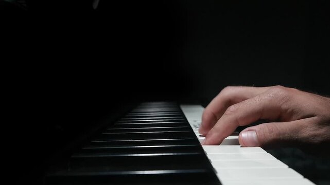 Monotony concept with a player repeating same tune on piano keys. Static shot close up of a person hand in training practice, dramatic dof light,no audio