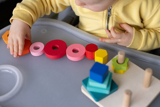 Baby playing with educational toy, Cognitive skills, Montessori activity. Closeup, selective focus.
