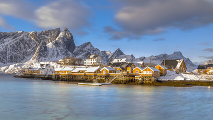 Yellow wooden fishing village in last sunlight in arctic fjord © creativenature.nl