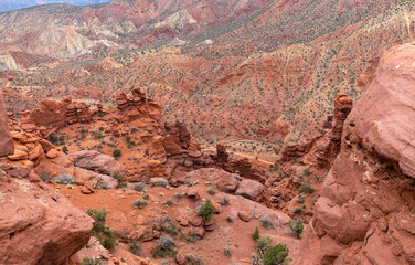Colorful red rock badlands with eroded sandstone hoodoos and a winding dirt road stretch below the end of the Fisher Towers trail near Moab, Utah, USA © Katrin