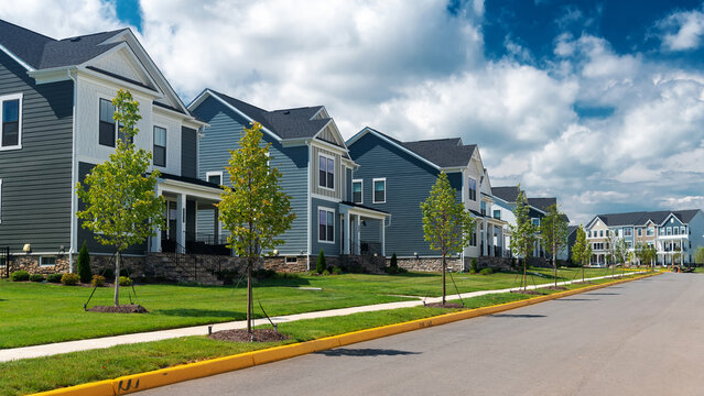 Modern detached homes line a quiet residential street in Leesburg, Virginia.