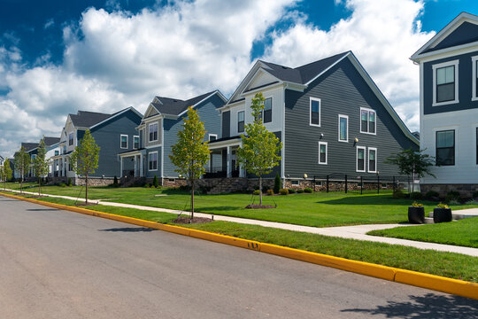 Curving residential street passes new detached homes in a Leesburg, Virginia community.