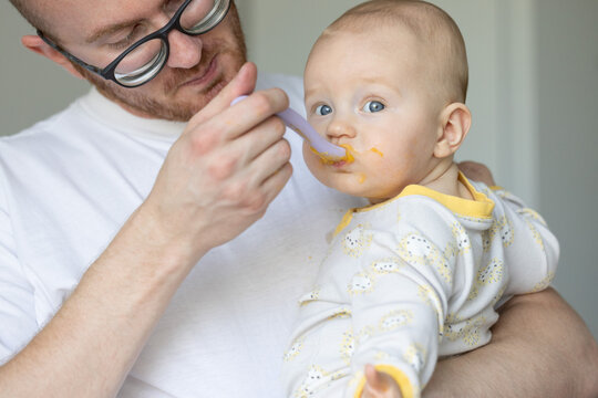 Father feeding his baby. Child likes to eat tasty baby food
