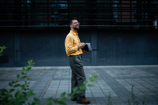 Young man smiling and looking up outdoors