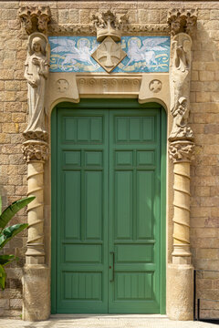 Modernist architectural details adorning a vibrant green wooden door, featuring intricate stone sculptures of figures and columns, with decorative ceramic tiles displaying mythical creatures
