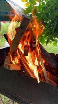 Close-up of burning firewood in a barbecue grill outdoors. High quality 4k footage