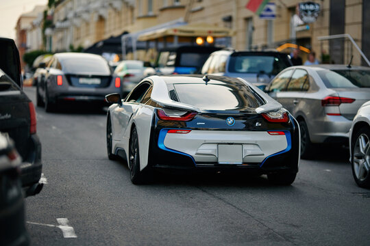Minsk, Belarus. Jun 6, 2025. BMW I8 sports car driving on busy european city street. White and black BMW I8 hybrid sports car driving down busy city street in the evening.