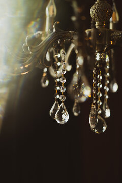 Close-up of elegant crystal chandelier pendant decorations hanging in dark interior.