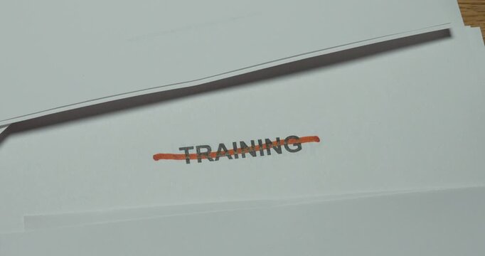 Close-up of the word Training being crossed out with a red pen. Concept for cancelled training, course cancellation, schedule changes and discontinued education.