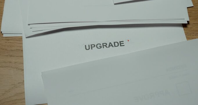 Hand revealing the word upgrade on a paper card, representing improvement, modernization and progress