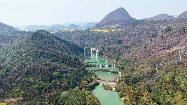 Aerial view of Jiulong Waterfalls in Luoping, Yunnan, China with turquoise water and green mountains in Jiulong Waterfalls, Luoping County, Yunnan, China