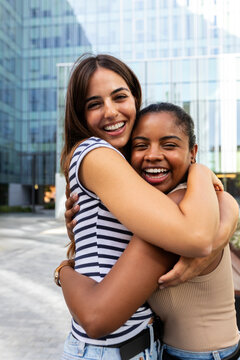 Happy multiracial women embracing and smiling outdoors