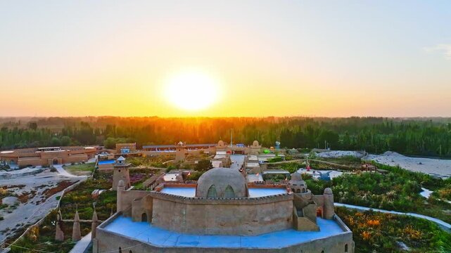Aerial Sunrise Over Historic Desert Fortress with Domes and Watchtowers