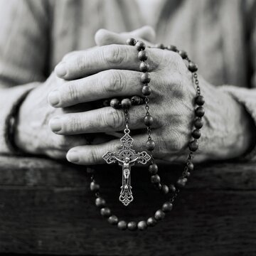 Close up of elderly hands holding a rosary in prayer conveying faith and devotion