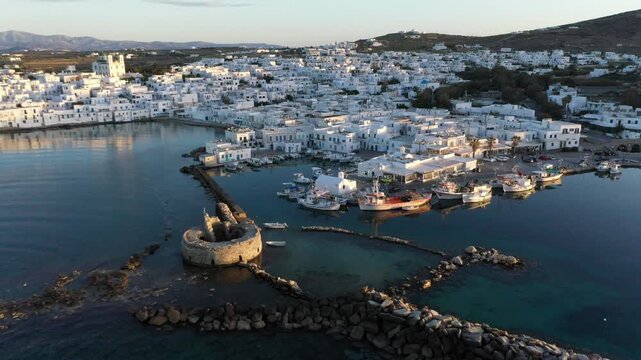 Coastal seaside town at sunset with white buildings and boats, Naousa, Paros, Greece