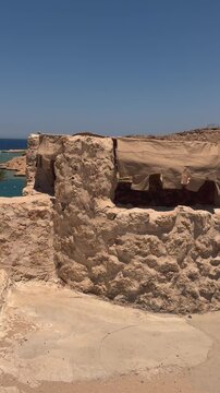 Ancient stone ruins overlooking the mediterranean sea with clear blue sky