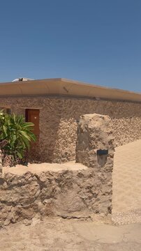Charming rustic stone house with desert plant under bright blue sky