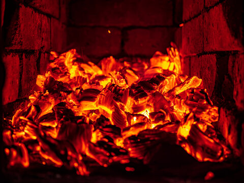 Glowing hot embers and burning wood in a brick fireplace