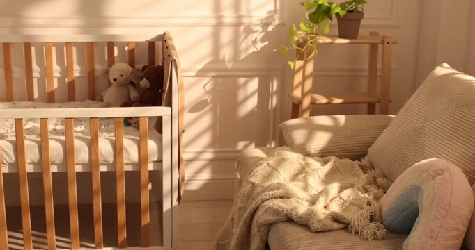 Stylish room with baby's crib and sofa. Camera moving left