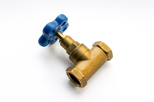 Brass water valve with blue handle isolated on white background to illustrate plumbing installation and pipeline maintenance systems. Real Photo