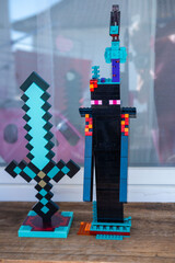 Obraz premium LEGO Minecraft Enderman figure tall black creature diamond sword built colorful blocks display wooden table background gaming merchandise collectible toy model construction, Childhood play creativity