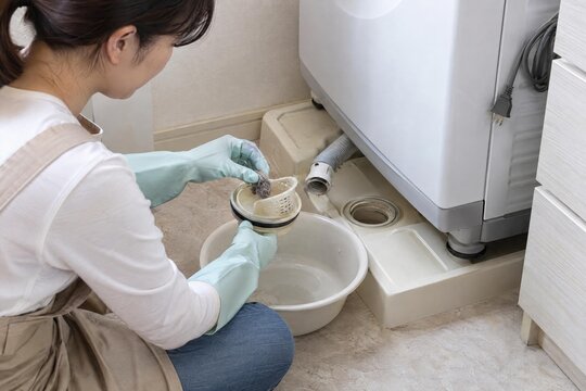 Cleaning a removable washing machine drain trap in a utility area