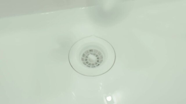 Opening a sink drain plug to drain water