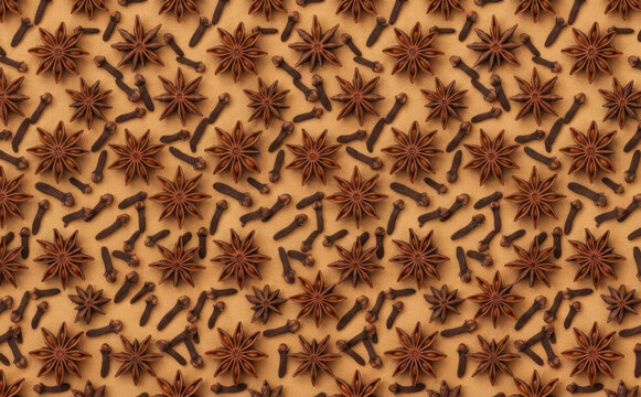 Star anise and cloves pattern background on warm beige surface, food spice design concept for culinary projects and autumn holiday baking photography