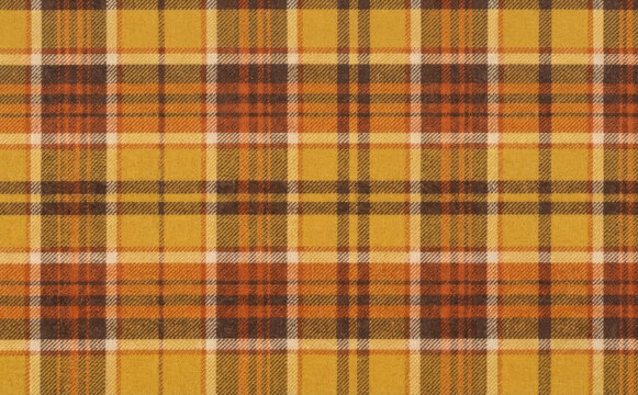 Autumn plaid flannel fabric texture pattern background with warm mustard yellow orange and brown check design for cozy autumn and winter seasonal apparel projects