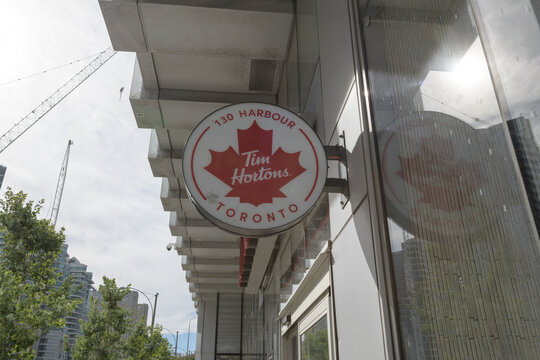 wall-mounted round projecting sign outside Tim Hortons, a coffee shop chain, located here at 130 Harbour St inside 10 York Street, Toronto