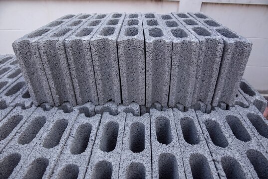 Stack of gray concrete cinder blocks piled together for construction building materials