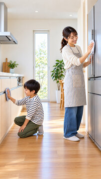 Mother and son wiping a refrigerator and kitchen cabinets，冷蔵庫とキッチンの収納扉を拭く母親と男の子