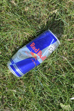 discarded metal can of RedBull on some grass in Toronto