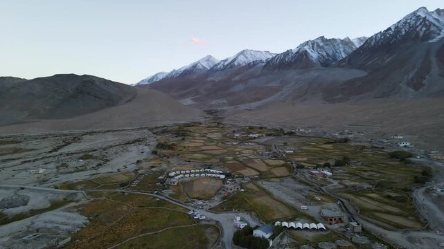 Stunning aerial view of mountain valley village surrounded by snow capped peaks near Pangong Tso in Ladakh