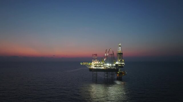 Offshore drilling rig - jack up and offshore platform during sunset for oil and gas exploration and production. 