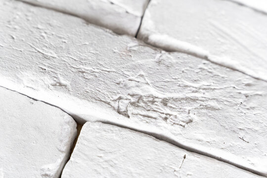 A closeup view shows white painted wooden planks with cracked and peeling texture, revealing a weathered rustic surface with visible brush strokes and grain.