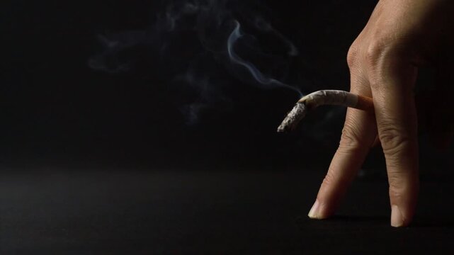 Bent cigarette between fingers symbolizing erectile dysfunction